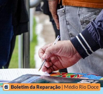 Imagem de um homem assinando um papel. Outras pessoas estão presentes.