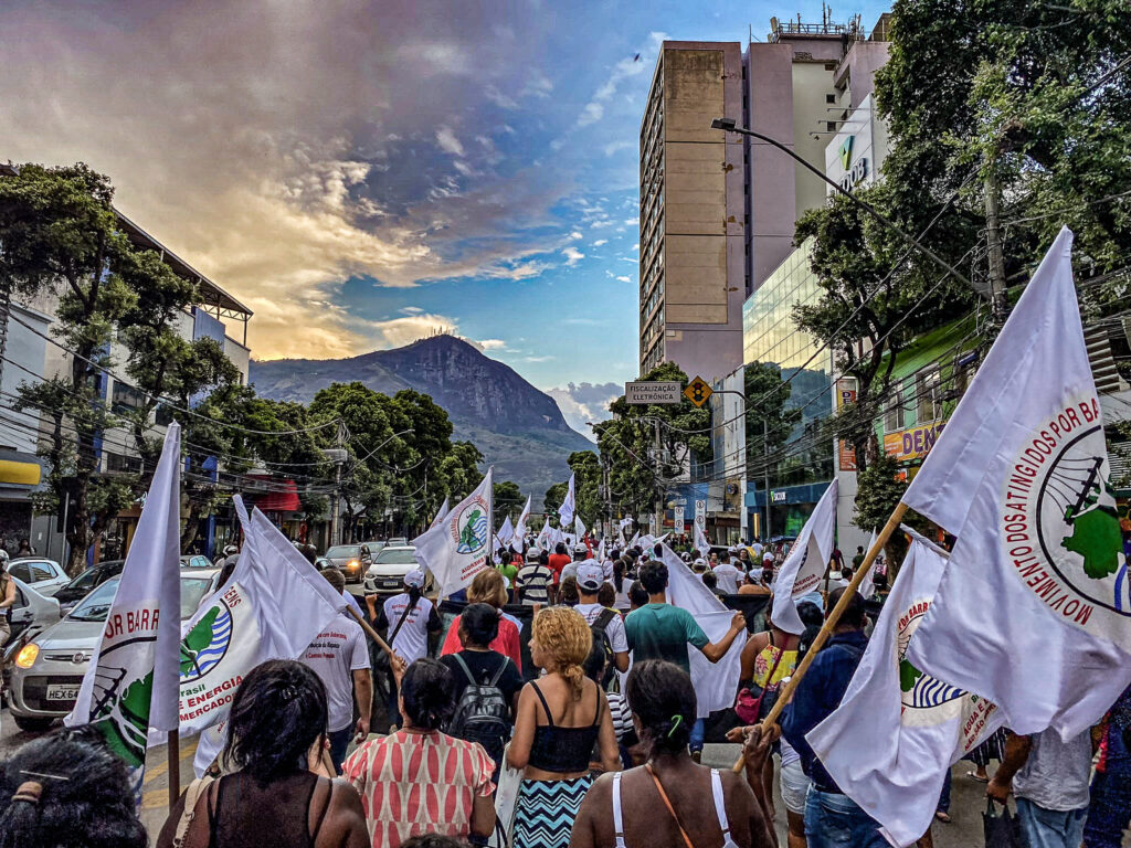 Pessoas atingidas participam de caminhada em Governador Valadares (MG), em setembro de 2023. Ao fundo, vê-se o Pico da Ibituruna.