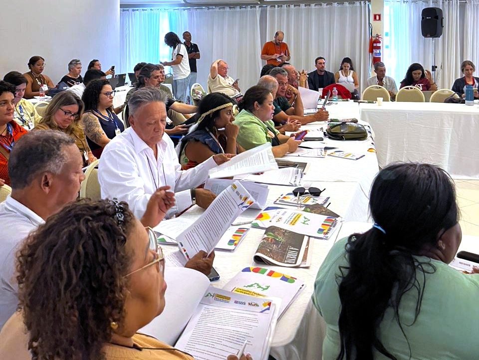 Conselheiros e conselheiras de toda a bacia se reúnem em Linhares (ES). No meio da foto se destaca o conselheiro Isac Pereira, do território 07 (Itueta e Resplendor), lendo um documento, ao lado de Meire Mniamá Purí, conselheira do território 08 (Aimorés).